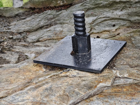 Plate and anchor bolt. Structural support on natural stone with gap to main plate and anchor boltsの写真素材