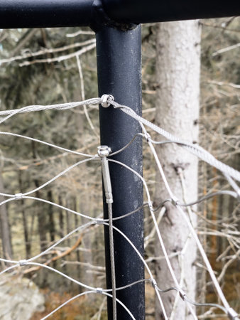 End tensioning joints on a modern wire fence. Anchor eye with thread and tensioning mechanism, safety equipmentの写真素材