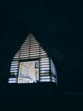 The white wooden board hut with big window between trees, camping in natureの写真素材