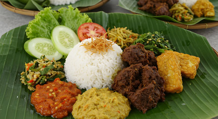 AI generative image of Nasi Padang, traditional Indonesian cuisine served on banana leaf with rice, rendang, tempe, and sambal. Perfect for culinary, restaurant, and culture themesの素材