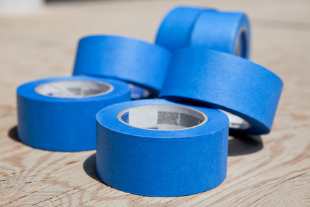 Roll of blue painters tapes over plywood の写真素材
