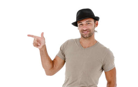 Smiling young man pointing copy space against white background の写真素材