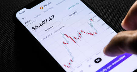 NEW YORK CITY, NY - March 23, 2020:  A businessman using a mobile phone to check bitcoin price.のeditorial素材