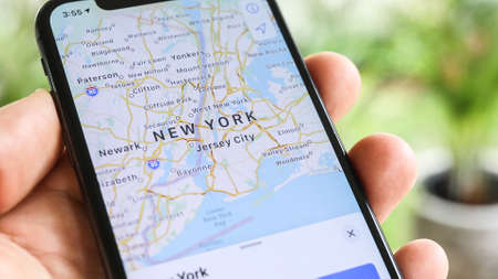 NEW YORK CITY, NY â€“ December 1, 2019:  Man using navigation application with his phone and...