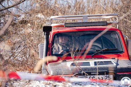 Khabarovsk, Russia - Nov 11, 2019: Jeep Suzuki Jimny overcomes obstacles in the forest.