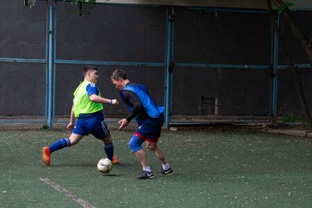 Street domestic playing soccer. Young guys play soccer on a green grassのeditorial素材