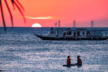 Sunset on the background of bottles standing on the bar. The sun passes through the bright glass of the bottles. Background image for the screensaver.のeditorial素材