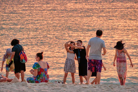 Boracay, Philippines - Jan 23, 2020: Sunset on the background of bottles standing on the bar. The sun passes through the bright glass of the bottles. Background image for the screensaver.のeditorial素材