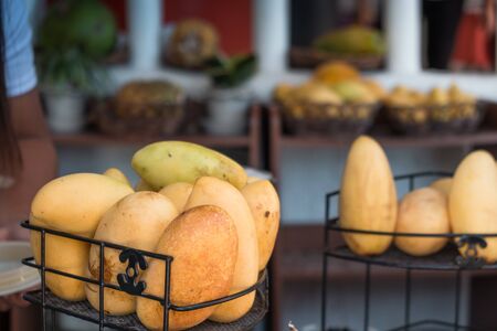 Yellow mango fruit in a basket at a street stall on Boracay island, Philippinesの写真素材