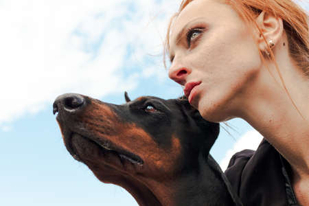 Khabarovsk, Russia - Sep 09, 2018: Fashion girl with red hair with a Doberman on the streetのeditorial素材