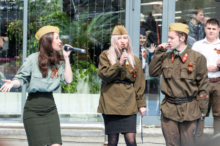 Khabarocsk, Russia - May 09, 2019: Concert in honor of the Victory Day in the great Patriotic war. Girls and a guy in a soldier's uniform sing songs on a military themeのeditorial素材