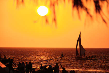 Boracay, Philippines - Jan 23, 2020: Sunset on Boracay island. Sailing and other traditional boats with tourists on the sea against the background of the setting sun.のeditorial素材
