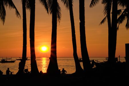 Sunset on Boracay island. Sailing and other traditional boats with tourists on the sea against the...
