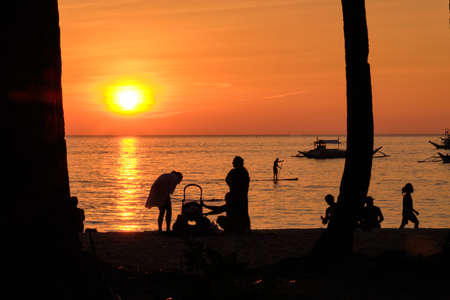 Sunset on Boracay island. Sailing and other traditional boats with tourists on the sea against the...