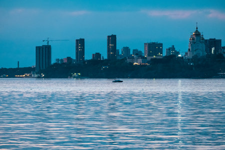 Night View of the city of Khabarovsk from the Amur river. Blue night sky. The night city is brightly lit with lanternsの写真素材
