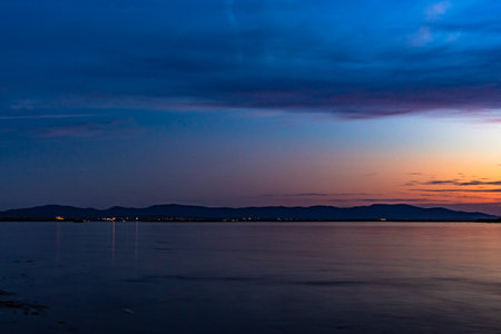 The sun went over the horizon of the Amur river in the city of Khabarovsk, forming magnificent colors in the sky. Beautiful colors in the sky, which are reflected in the water.の写真素材