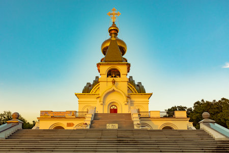Beautiful view during sunset at the temple of St. Seraphim of Sarov in the city of Khabarovsk. A beautiful green lawn in the foreground. Religious architecture, buildings and traditions. Russia.の写真素材