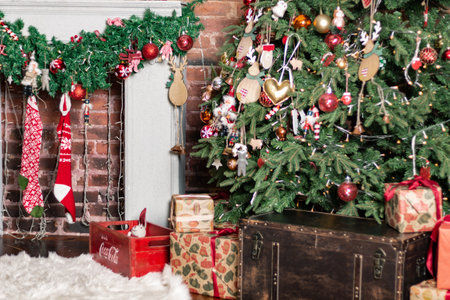 Gift boxes wrapped around the Christmas tree on the background. Cozy house is decorated to celebrate the New yearの写真素材