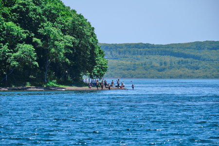 Novik Bay of the Russian island. People relax and sunbathe on the beach.のeditorial素材