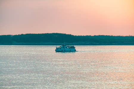 Sunset on the embankment of the Amur river in Khabarovsk. The sun set over the horizon. Passenger...