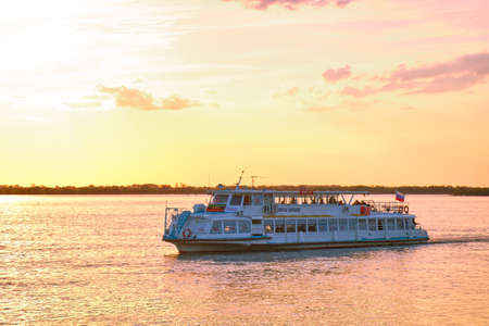 Khabarovsk, Russia - Sep 29, 2021: Sunset on the embankment of the Amur river in Khabarovsk. A pleasure boat is sailing on the river. The level of the Amur river at around 364 centimetersのeditorial素材