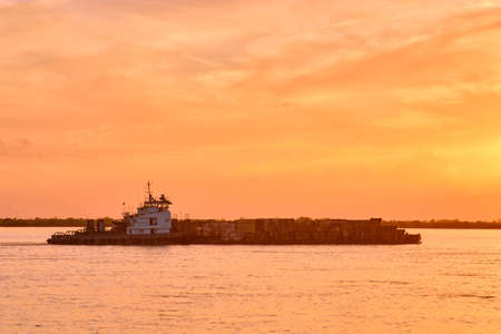Khabarovsk, Russia - Sep 29, 2021: Sunset on the embankment of the Amur river in Khabarovsk. A barge with timber floats on the river. The level of the Amur river at around 364 centimeters.のeditorial素材