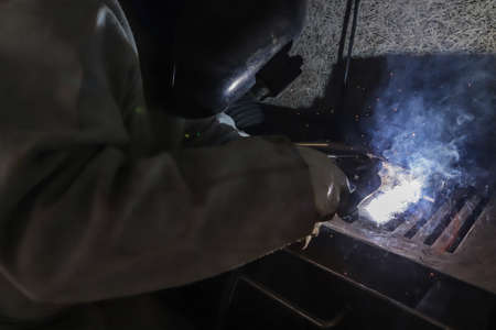 Sparks and light from work. In the image, it is possible to see the worker's hands and the...