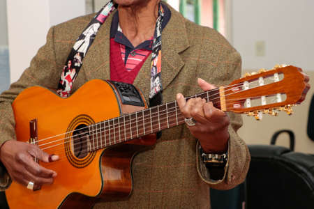 Image of a guitar player, without identifying the face, highlighting his hand, which is old, and is...