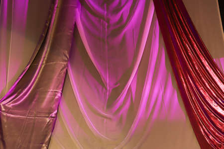 Bright fabrics in pink and red forming abstract inverted v designs.の写真素材