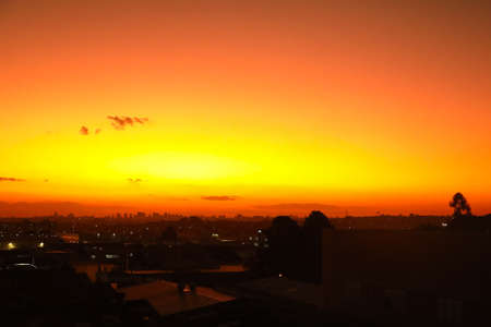 Sunset with a very orange sky, characteristic of the moment, and at the base of the image some city...