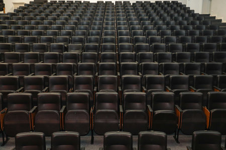 Theater auditorium with emphasis on the black chairs and wooden sides, all the same giving continuity and lines.の写真素材