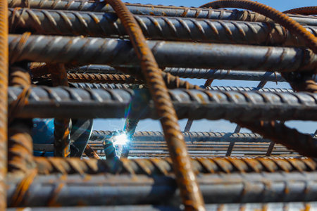 Reinforced iron lines and in the background a point of light coming from a weld to join the rebar.の写真素材