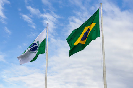 Flags of Brazil and the state of ParanÃ¡, located in the southern region of the country, on a blue sky between clouds.の写真素材