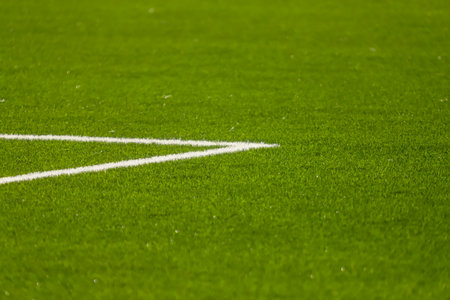 White lines painted on the grass of a soccer field, highlighting the green of the grass on a sunny...