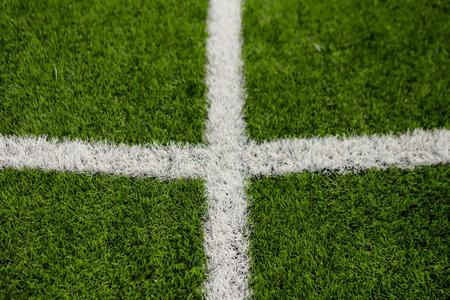 White lines painted on the grass of a soccer field, highlighting the green of the grass on a sunny...