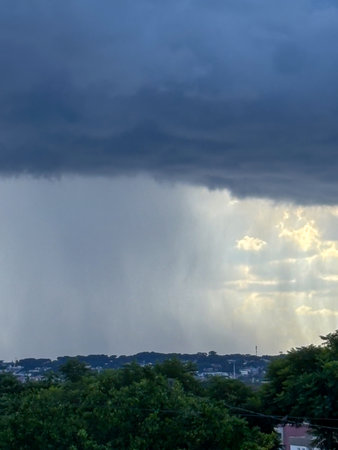 Image of rain on the horizon, with the left side showing rain and the right side showing orange...