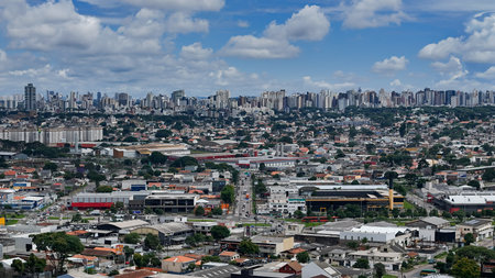 Panoramic image of the city of Curitiba, capital of the state of Parana. In the background you can see the buildings and the blue sky between clouds, and in the foreground you can see various buildings and streets.の写真素材