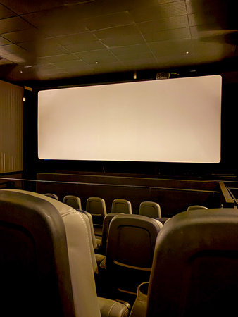 The image shows the interior of a movie theater, also known as a film projection room, with seats...
