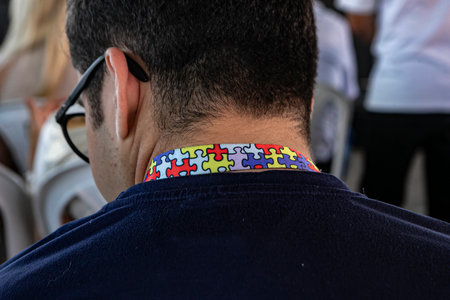 A person with their back turned, unable to identify them, is wearing a lanyard with a colorful...