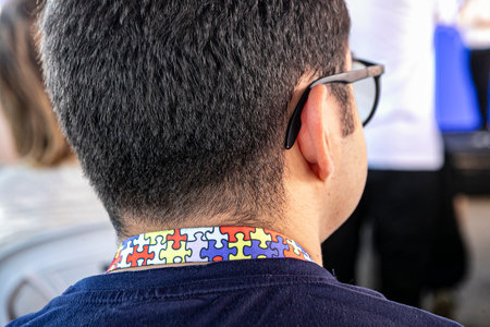 A person with their back turned, unable to identify them, is wearing a lanyard with a colorful...