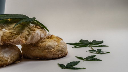 Homemade cupcakes (cake) with medical marijuana and a cap of tea with marijuana leaves on white backgroundの写真素材