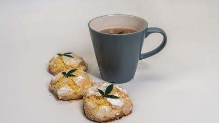 Homemade cupcakes (cake) with medical marijuana and a cap of tea with marijuana leaves on white backgroundの写真素材