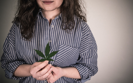 Person holding medical marijuana leaf in hands. Cannabis leaves. Herbal medicineの写真素材