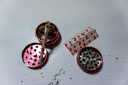 Medical marijuana joint with colored paper,  buds  and grinder lies on a white background. Cannabis, harvestの写真素材