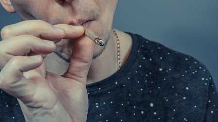 The person smoking medical marijuana joint close-up. Cannabis is medical. Legalization all over the worldの写真素材