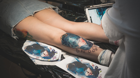 Professional tattoo artist stuffs a tattoo on a persons's body. Tattoo creation processのeditorial素材