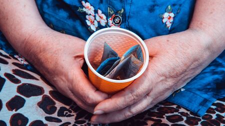 Old woman begs for alms. Closeup of money and coins in hand of poor woman. Social problems of societyの写真素材