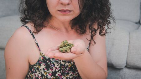 The young person are holding medical marijuana buds in his hand. Cannabis is a concept of herbal medicine. Marijuana is medicineの写真素材