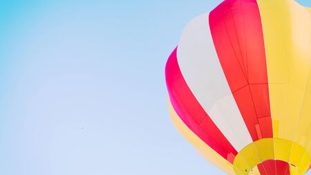 Colorful hot air balloons flying in the blue sky. Red and yellow colour of ballon, Clear and blue sky on the backgroundの写真素材