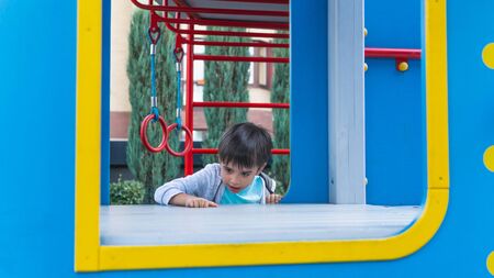 Happy smiling child on playground. Happy kids playing outdoors, clear summer dayの写真素材